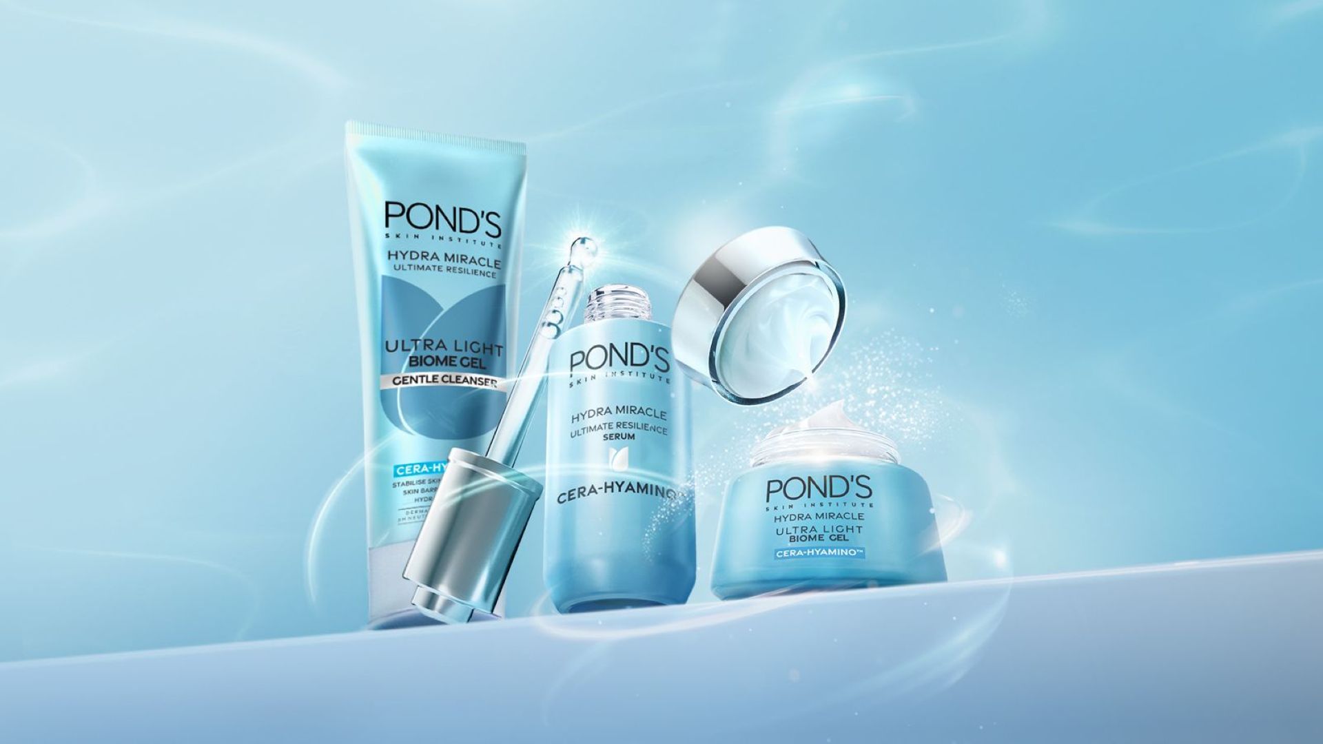 Três produtos Hydra Miracle Ultra Light da Pond’s. Azul com detalhes prateados. Abre-se um frasco de sérum com a pipeta visível.