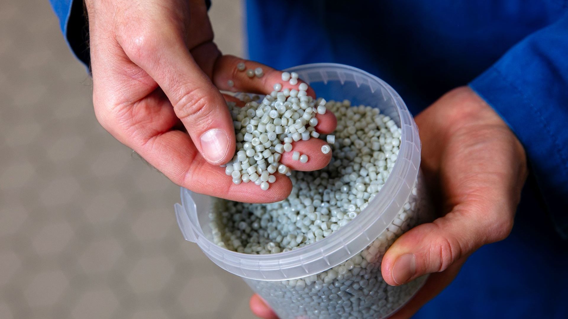 Cientista da Unilever mostrando grânulos de plástico reciclado
