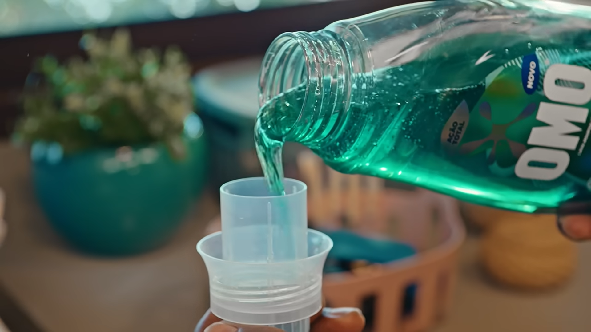 Detergente sendo despejado na tampa de uma garrafa de Omo.