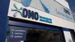 Uma unidade de OMO Lavanderia self-service, com o nome escrito em azul