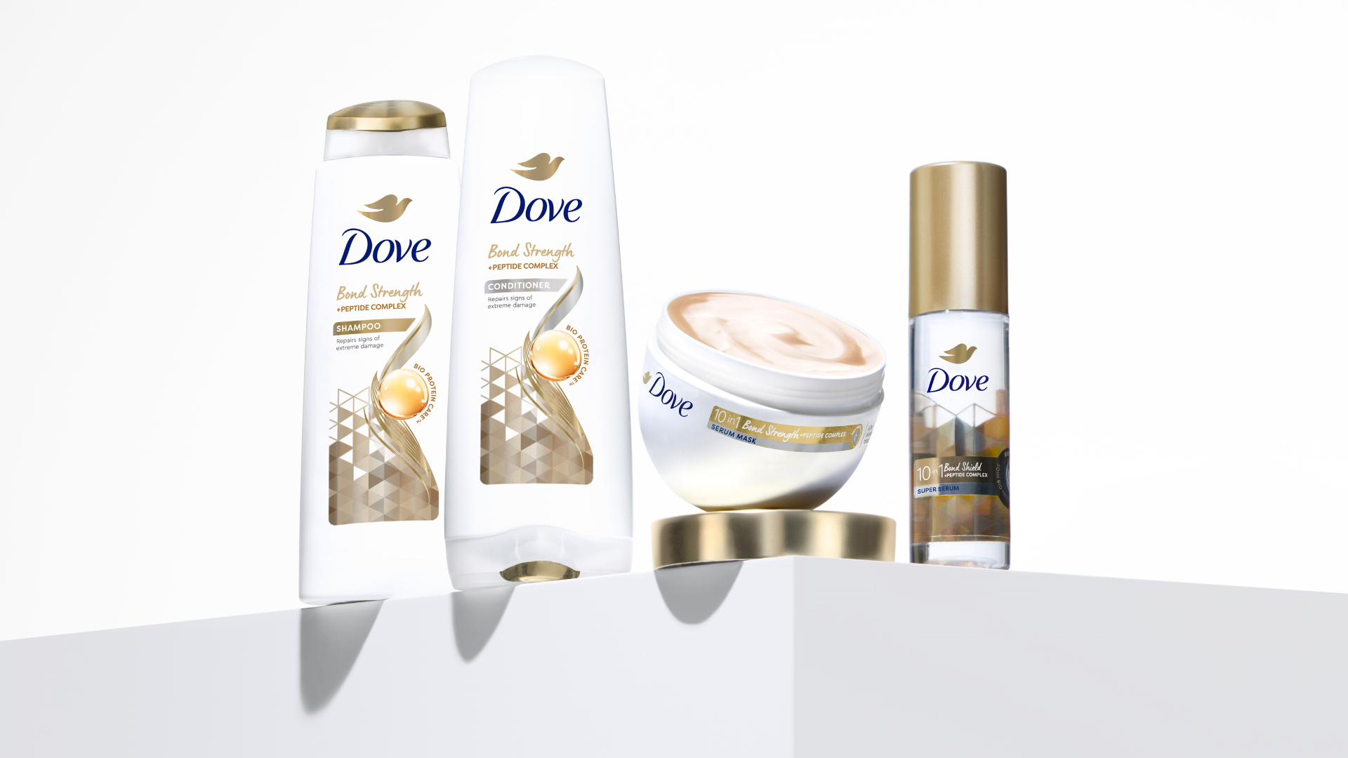 Quatro produtos da gama Bond Strength da Dove com avançadas tecnologias de fortalecimento de ligações para a reparação de danos capilares extremos.
