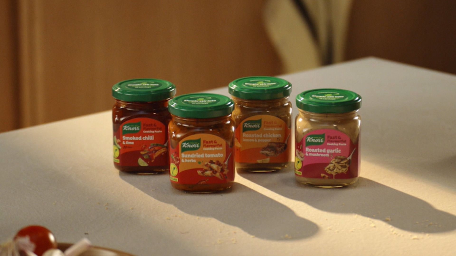 Quatro potes de Knorr Fast & Flavourful Paste sobre uma bancada branca de cozinha; IA reduziu o tempo de desenvolvimento pela metade.