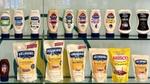 Uma prateleira com uma variedade de embalagens squeeze de maionese original e aromatizada da Hellmann's