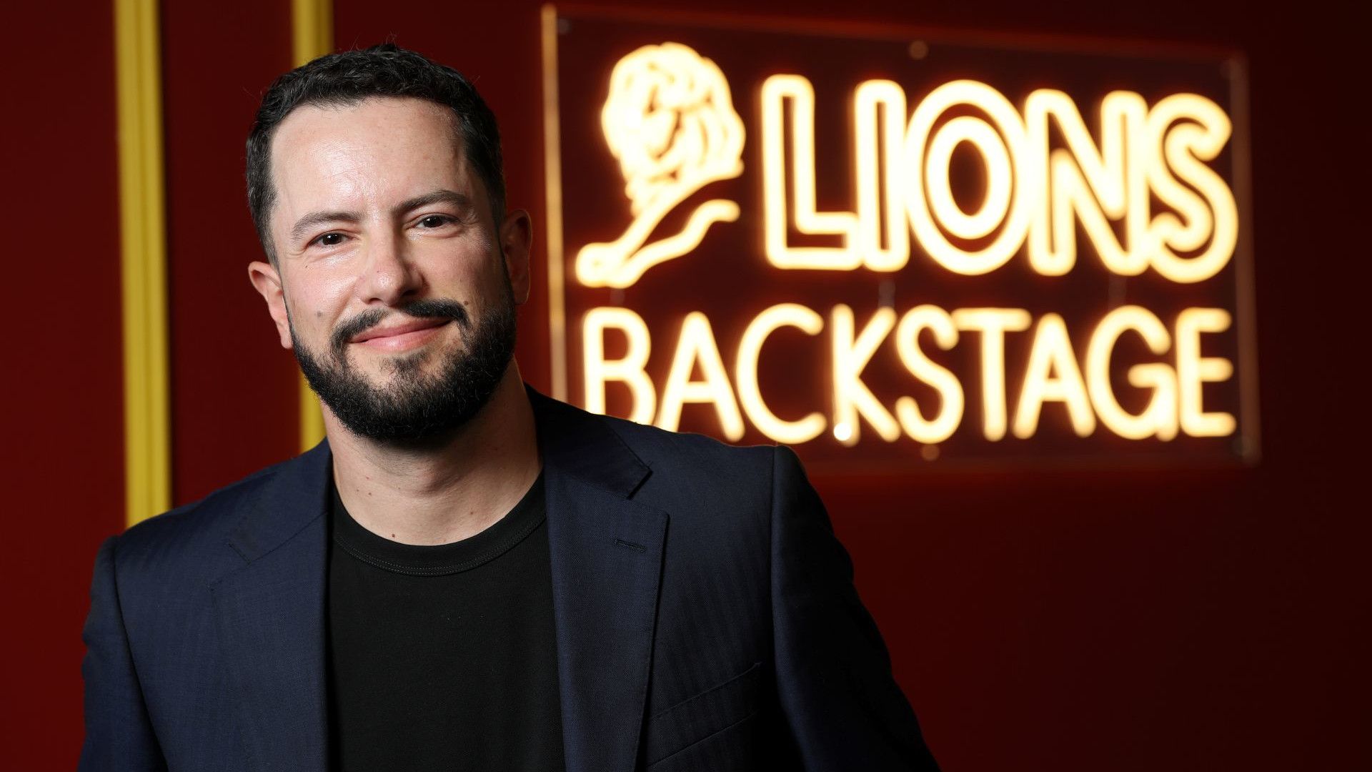 Leandro Barreto no Cannes Lions 2026, em frente a uma placa de neon com a frase “Lions Backstage”.